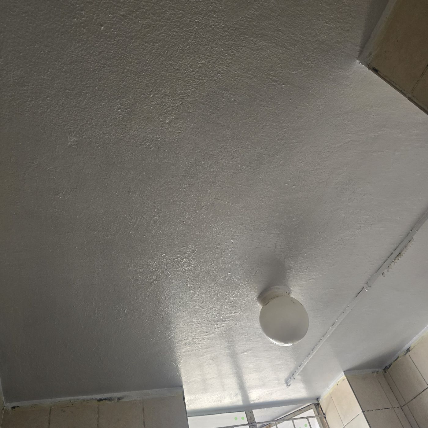 The same bathroom ceiling repainted clean white