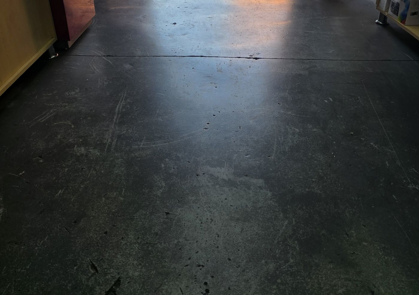 Worn, scratched concrete shop floor before epoxy coating