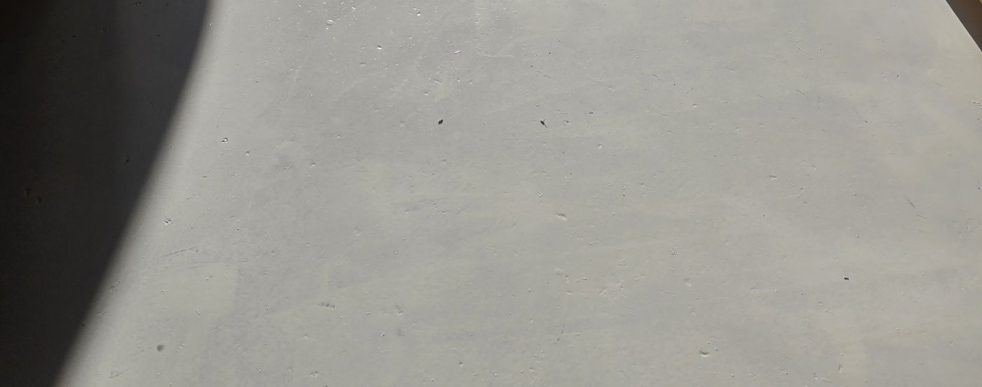 Smooth grey epoxy base coat completed across a shop floor