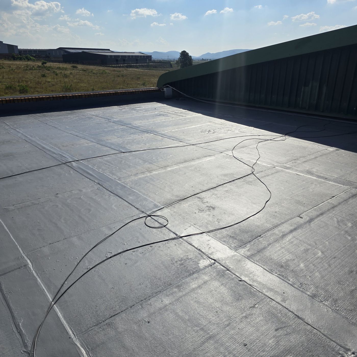Flat roof with a dark grey waterproofing membrane