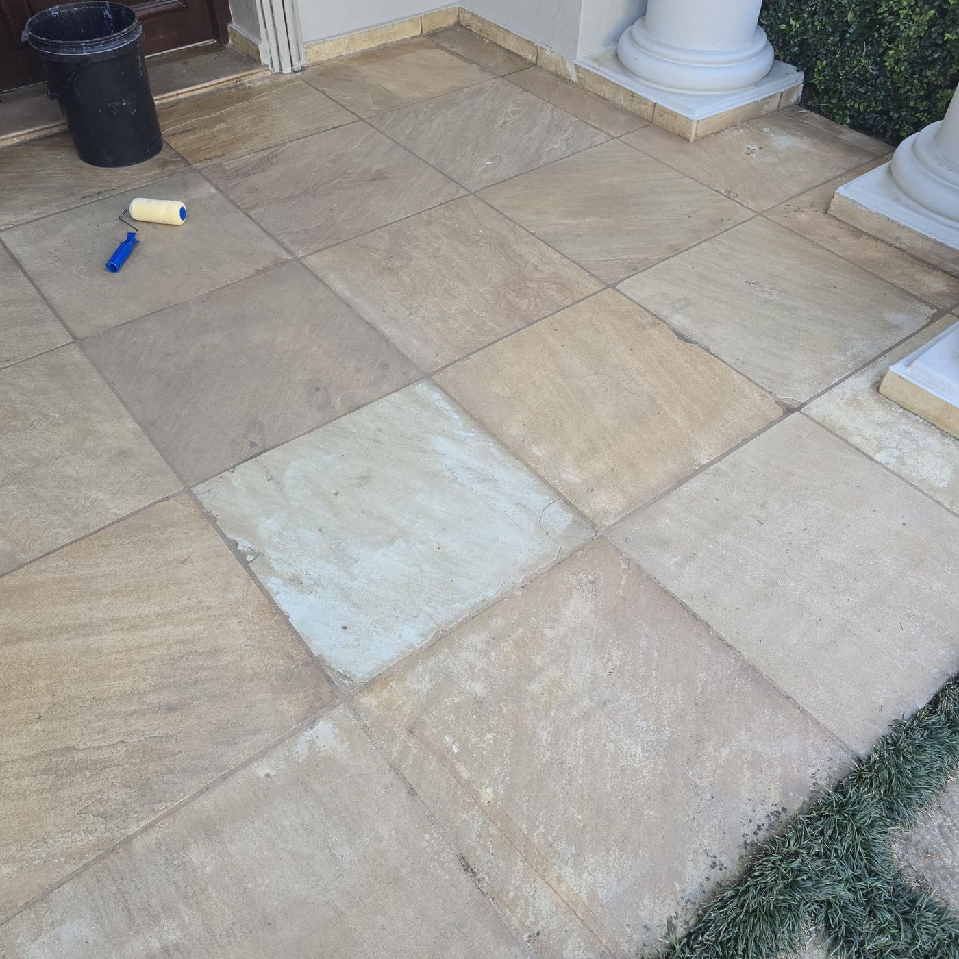 Dry, dull stone tiles at a front door before coating