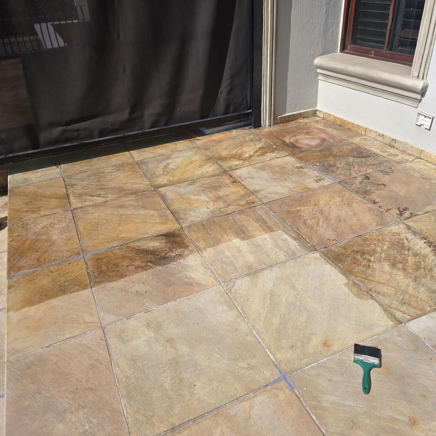 Stone tiles with polyurethane going on, treated and untreated tiles side by side