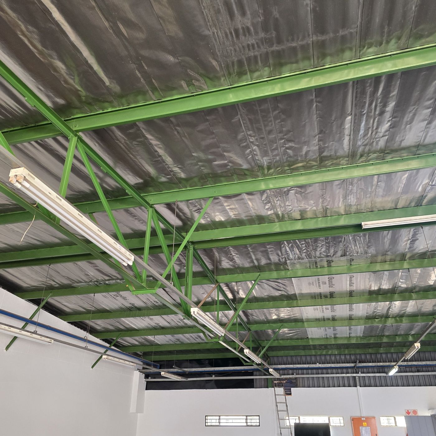 Warehouse ceiling with green steel beams before repainting