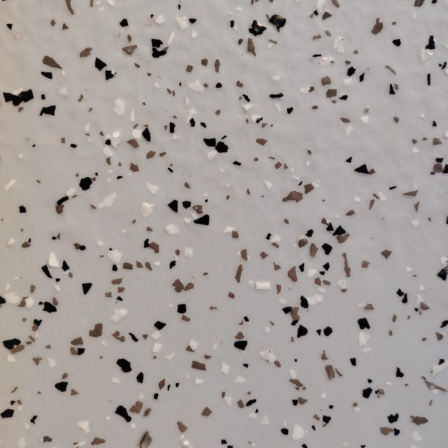 Epoxy floor colour and finish sample: sparse black, brown and white flakes on pale grey